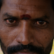 A fruit juice seller in Chennai stares intently into the camera.
